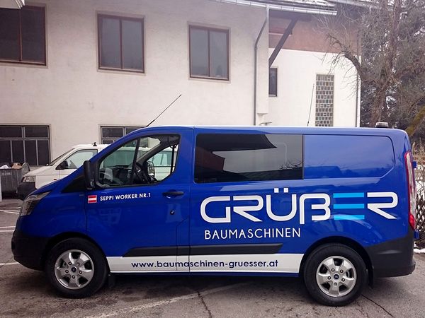 Gruesser Baumaschinen Radstadt - Ford Tranist mit Hochleistungsfolien in blau und weiss beschriftet