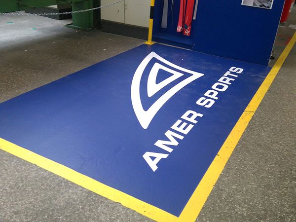 Amer Sports - Aufkleber aus Digitaldruck mit Bodenlaminat am Boden verklebt