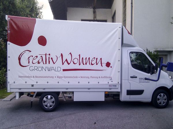 Creativ Wohnen Eben - Planenwagen beschriftet mit gegossenen roten und schwarzen Hochleistungsfolien