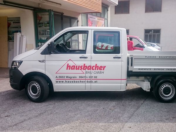 Hausbacher Bau Wagrain - VW Pritsche mit gegossenen Hochleistungsfolien beschriftet