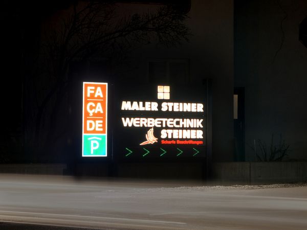 Malerei Steiner und Werbetechnik Steiner - Leuchtpylon mit dekupierter Schrift und durchgesteckten leuchtenden Plexibuchstaben Nachtansicht