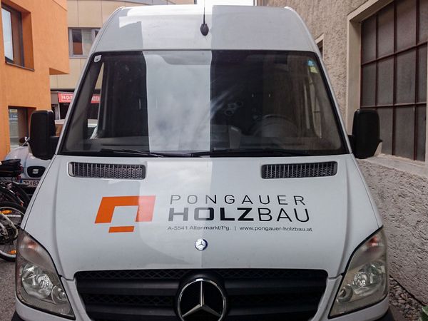 Pongauer Holzbau Altenmarkt - Mercedes Sprinter mit gegossener oranger und schwarzer Hochleistungsfolie