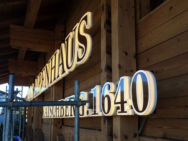 Hotel Alpenhaus Katschberg - LED Front- und Zargenleuchter aus Plexi mit Blickdichter Folie beschriftet, warmweiss leuchtend